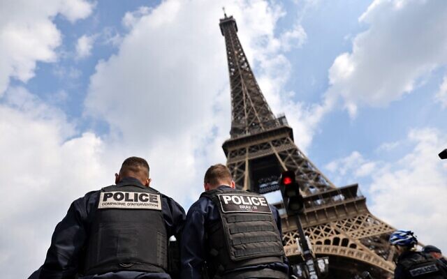 Police officers are seen in front of the Eiffel Tower during a large police operation around the Eiffel Tower area in Paris, on April 26, 2022. (Photo by Thomas COEX / AFP)