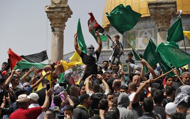 Palestinians wave Palestinian and Islamic flags as they rally at the Al-Aqsa Mosque on the Temple Mount in Jerusalem, following the last Friday prayers of the Muslim holy month of Ramadan, on April 29, 2022. (Ahmad Gharabli/AFP)