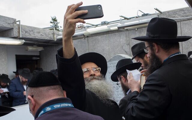 A man takes a selfie while visiting the grave of Rabbi Menachem Mendel Schneerson, the former head of the Lubavitch movement, in Queens, New York, Nov. 2, 2018. (Andrew Lichtenstein/Corbis via Getty Images, via JTA)