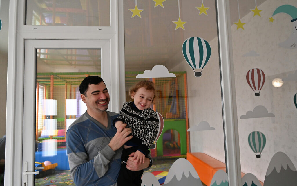 Stanislav Gluzman and his son Mikhail laugh at the refugee camp in Irshava, Ukraine, April 5, 2022. (Cnaan Liphshiz/ JTA)