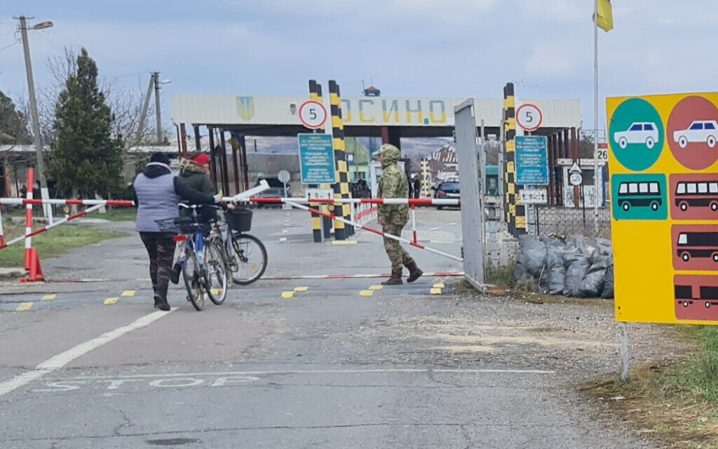 A cyclist crosses the Kosyno border crossing from Hungary into Ukraine, April 5, 2022. (Cnaan Liphshiz/ JTA)