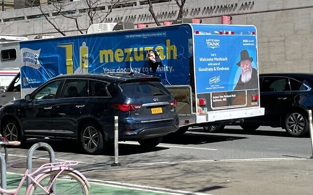 A young man pokes his head out of a Mitzvah Tank as it drives up Amsterdam Avenue in Manhattan, April 12, 2022. (Jackie Hajdenberg via JTA)