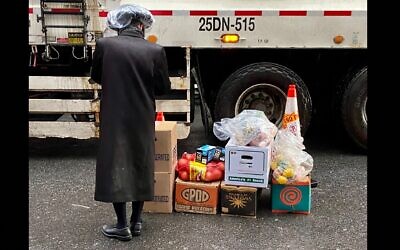 A Satmar Orthodox man volunteers to deliver free food provided by Met Council at a distribution center at the Brooklyn Navy Yard run by the United Jewish Organizations of Williamsburg, on April 10, 2022. (Jacob Henry/JTA)