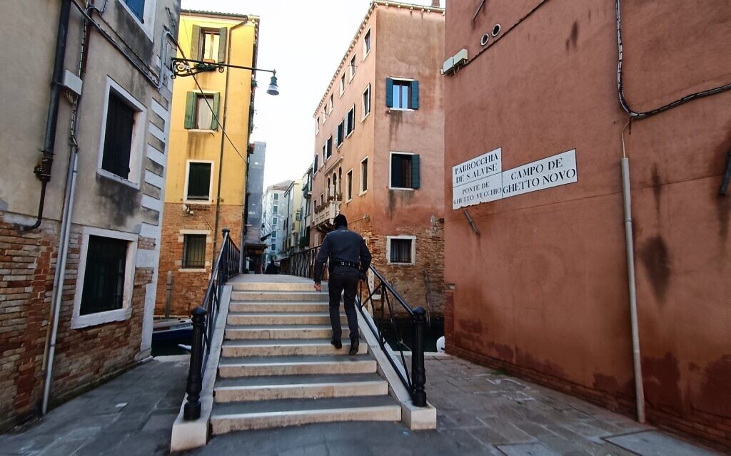 A guard climbs stairs by the entrance to the Campo di Ghetto Nuovo, or former Jewish Ghetto, in Venice. (Orge Castellano/JTA)