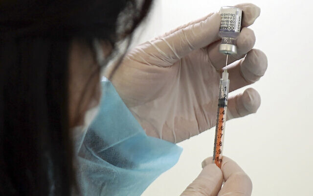 A health worker prepares a dose of the Pfizer COVID-19 vaccine. (AP Photo/Eugene Hoshiko)