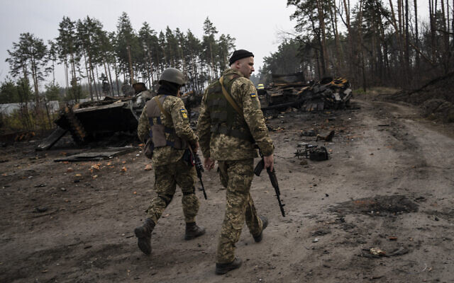 Ukrainian soldiers walk next to destroyed Russian tanks in the outskirts of Kyiv, Ukraine, March 31, 2022. (AP Photo/Rodrigo Abd)