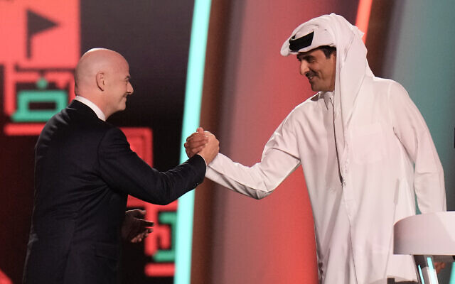 FIFA President Gianni Infantino, left, and Emir of Qatar Sheikh Tamim bin Hamad Al Thani shake hands before the 2022 soccer World Cup draw at the Doha Exhibition and Convention Center in Doha, Qatar, April 1, 2022. (AP Photo/Hassan Ammar)