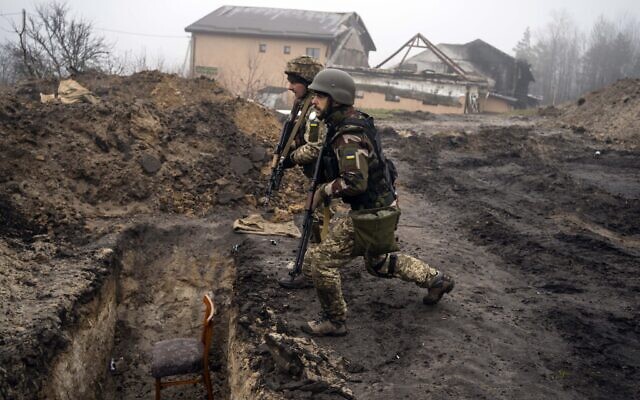Ukrainian soldiers approach a trench that had been used by Russian soldiers as they retake an area on the outskirts of Kyiv, Ukraine, April 1, 2022. (AP Photo/Rodrigo Abd)