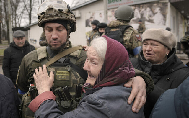 A woman hugs a Ukrainian serviceman after a convoy of military and aid vehicles arrived in the formerly Russian-occupied Kyiv suburb of Bucha, Ukraine, April 2, 2022. (AP Photo/Vadim Ghirda)