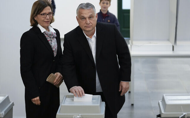 Hungary's nationalist prime minister, Viktor Orban, center, and his wife Aniko Levai, left, cast their vote for general election in Budapest, Hungary, Sunday, April 3, 2022. Orban seeks a fourth straight term in office, a coalition of opposition parties are framing the election as a referendum on Hungary's future in the West. (AP Photo/Petr David Josek)