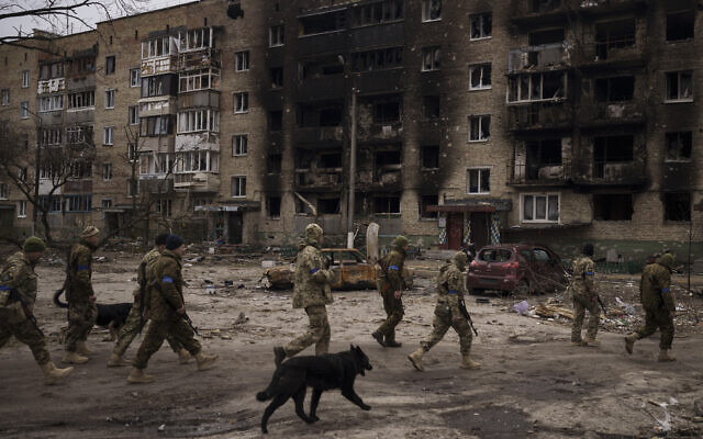 Ukrainian soldiers walk next to heavily damaged residential buildings in Irpin, on the outskirts of Kyiv, Ukraine, on April 6, 2022. (AP Photo/Felipe Dana)