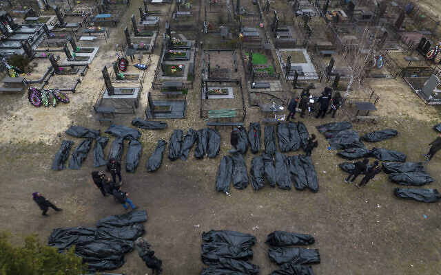 Policemen work on the identification process following the killing of civilians in Bucha, before sending the bodies to the morgue, on the outskirts of Kyiv, Ukraine, on April 6, 2022. (AP Photo/Rodrigo Abd)