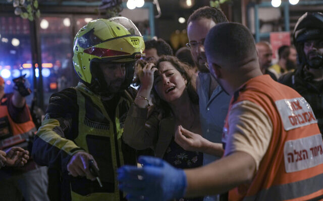 A woman reacts at the scene of a terror attack In Tel Aviv, Israel, Thursday, April 7, 2022 (AP Photo/Ariel Schalit).
