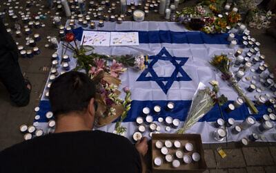 People light candles at the site of the April 7 shooting attack in Tel Aviv, Israel, April 8, 2022. (AP Photo/Oded Balilty)