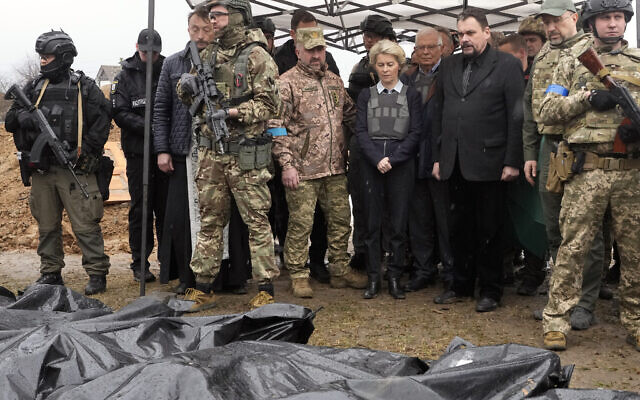 EU Commission President Ursula von der Leyen, center, looks at covered bodies of killed civilians in Bucha, on the outskirts of Kyiv, Ukraine, April 8, 2022. (AP Photo/Efrem Lukatsky)