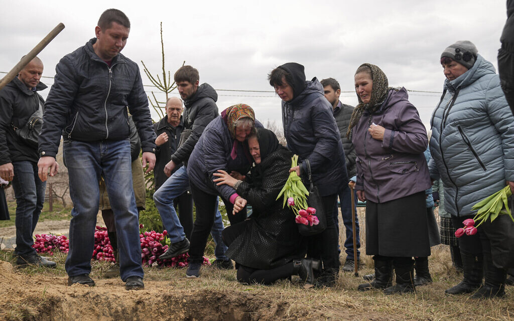 Liudmila Sumanchuk, center in black coat, the grandmother of Veronika Kuts cries during her funeral ceremony in L'giv village, Chernihiv region, Ukraine, on April 8, 2022 (AP Photo/Evgeniy Maloletka)