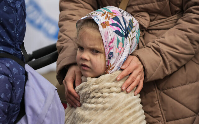 A refugee child waits in a line after fleeing the war from neighboring Ukraine at the border crossing in Medyka, southeastern Poland, Sunday, April 10, 2022. (AP Photo/Sergei Grits)