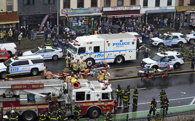 Emergency personnel gather at the entrance to a subway stop in the Brooklyn borough of New York, on April 12, 2022. (AP Photo/John Minchillo)