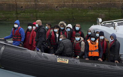 A group of people thought to be migrants are brought in to Dover, Kent, in the United  Kingdom, on board a Border Force vessel following a small boat incident in the Channel, April 13, 2022. (Gareth Fuller/PA via AP)