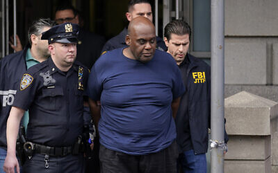 New York City Police and law enforcement officials lead subway shooting suspect Frank R. James, 62, center, away from a police station, in New York, on April 13, 2022. (AP Photo/Seth Wenig)