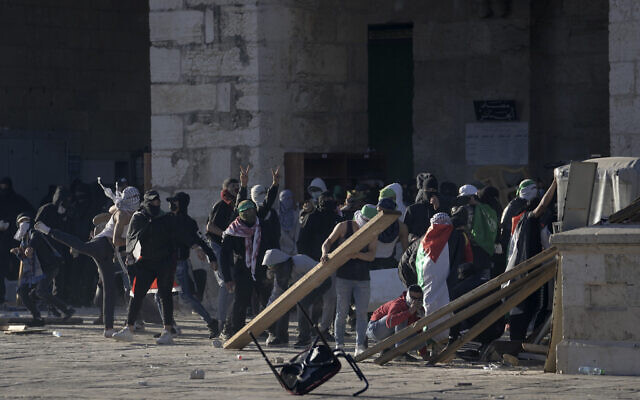 Palestinians clash with Israeli security forces at the Al Aqsa Mosque compound atop the Temple Mount in Jerusalem's Old City Friday, April 15, 2022. (AP Photo/Mahmoud Illean)
