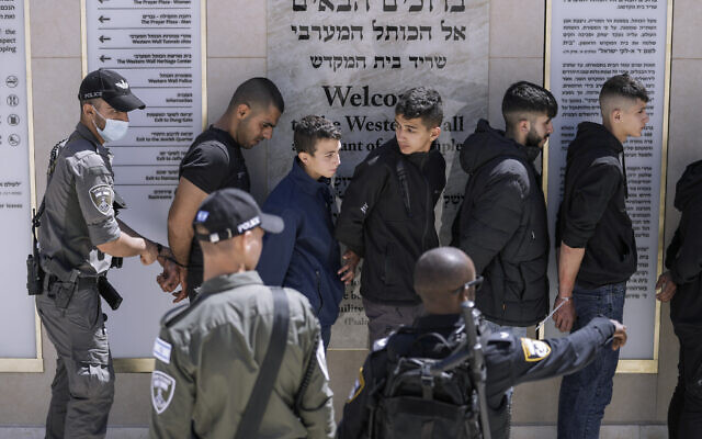 Detained Palestinian demonstrators are handcuffed following clashes at the Al-Aqsa Mosque compound between Palestinians and Israeli police, at the Temple Mount in Jerusalem's Old City, on April 15, 2022. (AP Photo/Ariel Schalit)