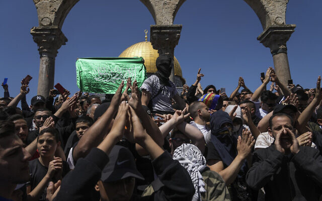 Palestinians chant slogans and wave Hamas flags during a protest against Israel, in front of the Dome of the Rock shrine at the Aqsa Mosque compound atop the Temple Mount in Jerusalem's Old City, April 15, 2022. (AP Photo/Mahmoud Illean)