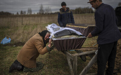 Nadiya Trubchaninova, 70, cries while holding the coffin of her son Vadym, 48, who was killed by Russian soldiers last March in Bucha, during his funeral in the cemetery of Mykulychi, on the outskirts of Kyiv, Ukraine, on April 16, 2022. (AP Photo/Rodrigo Abd)