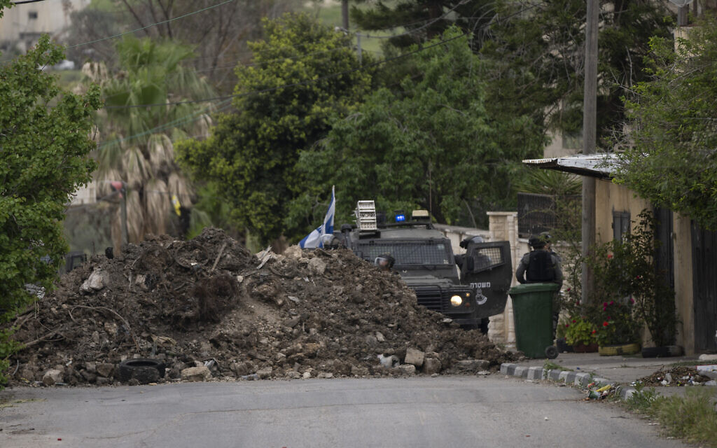 Israeli border police use a mound of earth to close the main entrance of the West Bank village of Burqa, north of Nablus, Tuesday, April 19, 2022. (AP/Nasser Nasser)