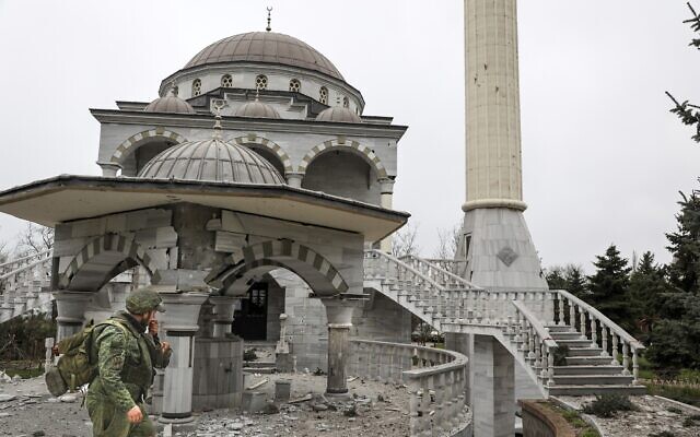 A serviceman of the Donetsk People’s Republic militia walks past a damaged mosque during heavy fighting in an area controlled by Russian-backed separatist forces in Mariupol, Ukraine, on April 19, 2022. (AP Photo/Alexei Alexandrov)