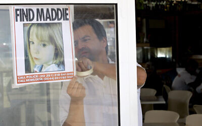 File: A waiter hangs a picture of missing Madeleine McCann on a restaurant's window, May 10 2007, in Praia da Luz, southern Portugal. (AP Photo/Armando Franca)