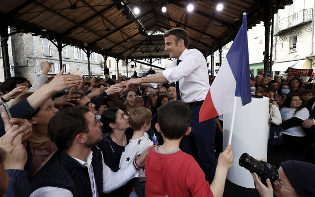 Centrist candidate and French President Emmanuel Macron reacts as he meets residents after a campaign rally, on Friday, April 22, 2022 in Figeac, southwestern France. Emmanuel Macron is facing off against far-right challenger Marine Le Pen in France's April 24 presidential runoff. (Benoit Tessier, Pool via AP)