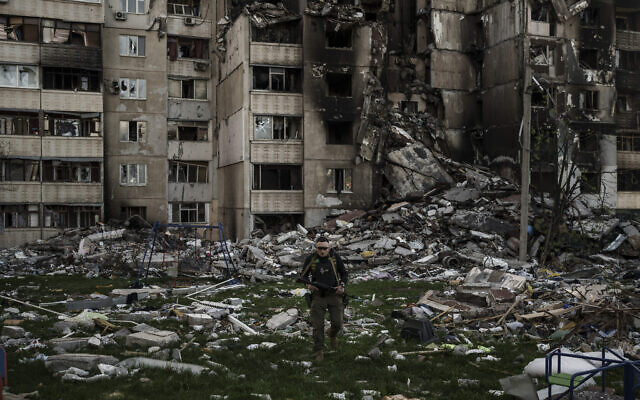 A Ukrainian serviceman walks amid the rubble of a building heavily damaged by multiple Russian bombardments near a frontline in Kharkiv, Ukraine, on Monday, April 25, 2022. (AP Photo/Felipe Dana)