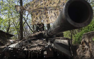 Ukrainian serviceman install a machine gun on the tank during the repair works after fighting against Russian forces in Donetsk region, eastern Ukraine, April 27, 2022. (AP Photo/Evgeniy Maloletka)