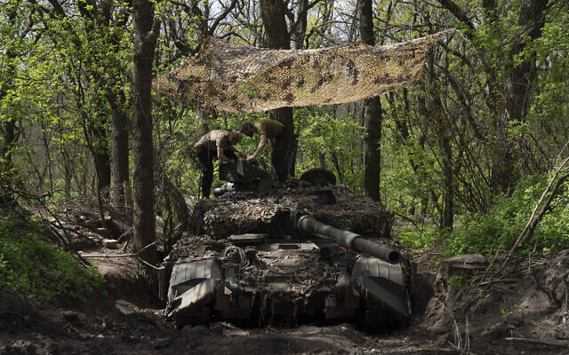 Ukrainian servicemen install a machine gun on a tank during the repair works after fighting against Russian forces in Donetsk region, eastern Ukraine, April 27, 2022. (AP Photo/Evgeniy Maloletka)