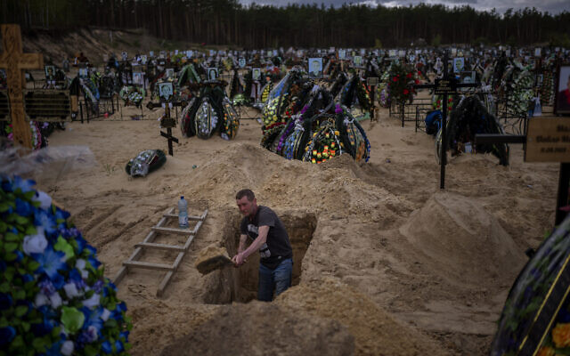 Gravedigger Alexander, digs a grave at the cemetery of Irpin, on the outskirts of Kyiv, on April 27, 2022. (AP Photo/Emilio Morenatti)