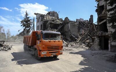 A truck drives past the Mariupol theater damaged during fighting in Mariupol, in territory under the government of the Donetsk People's Republic, eastern Ukraine, April 27, 2022. Municipal services began clearing rubble and cleaning the city. (AP Photo/Alexei Alexandrov)