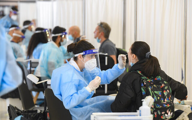 Medical technicians test passengers for COVID-19 at Ben Gurion Airport, on March 8, 2021. (Flash90)