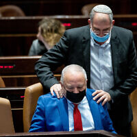 MK Nir Orbach (standing) seen with Finance Minister Avigdor Liberman during a Knesset plenum session, November 29, 2021. (Yonatan Sindel/Flash90)