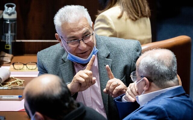 MK Mazen Ghanaim (center) speaks with MK Ahmad Tibi during a Knesset plenum session, January 5, 2022. (Yonatan Sindel/Flash90)