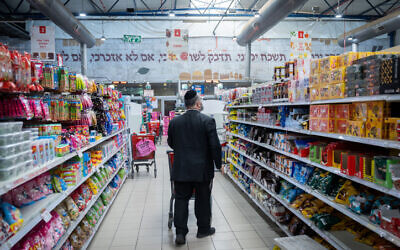 A man shops for groceries at a Rami Levy supermarket in Jerusalem on February 3, 2022. (Yonatan Sindel/Flash90)