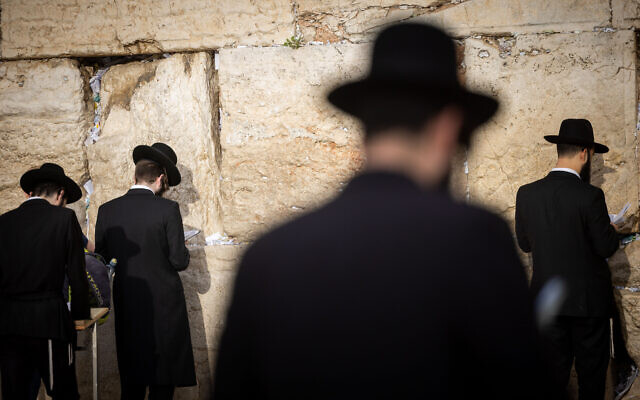 Illustrative: Jewish men pray at the Western Wall in Jerusalem's Old City, on March 2, 2022. (Yonatan Sindel/Flash90)