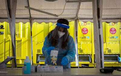 A Magen David worker takes a COVID-19 rapid antigen test from Israelis, at a Magen David Adom drive through complex in Jerusalem, on March 22, 2022. (Olivier Fitoussi/Flash90)