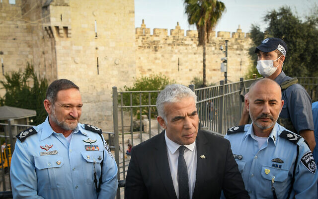 Foreign Minister Yair Lapid (center), Israel Police Commissioner Kobi Shabtai and Jerusalem District Commander Doron Turgeman at the Damascus Gate in Jerusalem's Old City, April 3, 2022. (Arie Leib Abrams/Flash90)