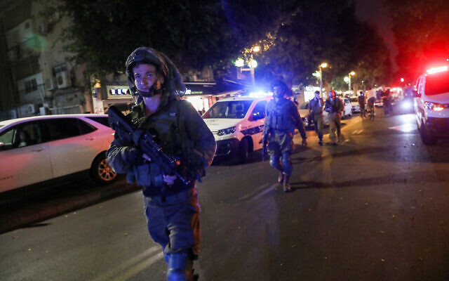 Israeli soldiers search at the scene of a terror attack on Dizengoff street, central Tel Aviv, April 7, 2022. Two people were killed and several more injured in the attack. (Noam Revkin Fenton/Flash90)