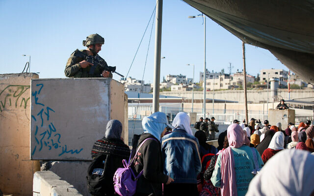 Illustrative: Palestinian women cross the Qalandiya checkpoint, outside of the West Bank city of Ramallah, on April 15, 2022. (Flash90)
