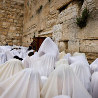 Jewish worshippers cover themselves with prayer shawls as they take part in the priestly blessing for Passover at the Western Wall in Jerusalem's Old City, April 20, 2022. (Olivier Fitoussi/Flash90)