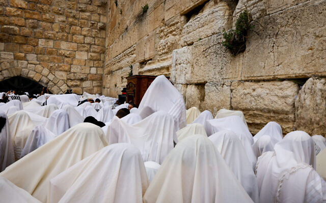 Jewish worshippers cover themselves with prayer shawls as they take part in the priestly blessing for Passover at the Western Wall in Jerusalem's Old City, April 20, 2022. (Olivier Fitoussi/Flash90)