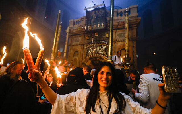 Christian pilgrims hold candles as they gather during the ceremony of the Holy Fire at Church of the Holy Sepulchre, where many Christians believe Jesus was crucified, buried and rose from the dead, in the Old City of Jerusalem on April 23, 2022. (Olivier Fitoussi/Flash90)