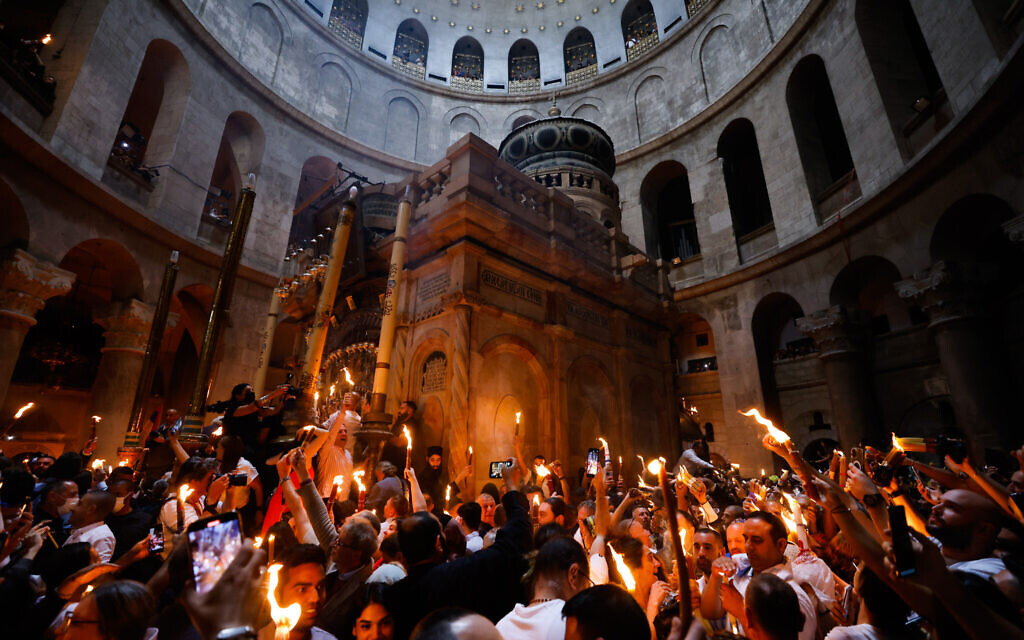 Christian pilgrims hold candles as they gather during the ceremony of the Holy Fire at Church of the Holy Sepulchre, where many Christians believe Jesus was crucified, buried and rose from the dead, in the Old City of Jerusalem, on April 23, 2022. (Olivier Fitoussi/Flash90)